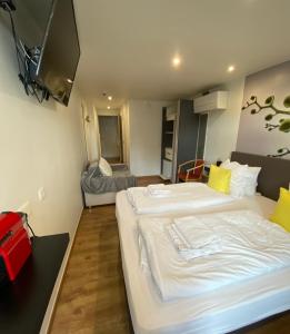 a hotel room with two beds and a television at Hotel De Backer in Knokke-Heist