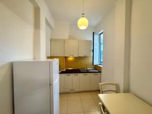a kitchen with a white refrigerator and a table at Central Loft in Tirana