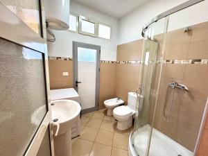 a bathroom with a toilet and a sink and a shower at Central Loft in Tirana +12 photos