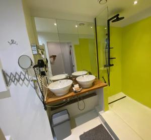 a bathroom with three sinks and a mirror at Hotel De Backer in Knokke-Heist +23 photos
