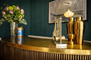 a table with gold bottles and a vase of flowers at Clarence House in Derry Londonderry +180 photos