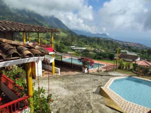 a resort with a pool and mountains in the background at Finca la pilarica in Istmina +4 photos