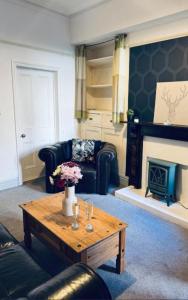 a living room with a couch and a coffee table at Harrington House - Perfect for contractors Sleeps 15 in Workington
