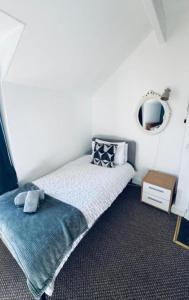a small bedroom with a bed and a mirror at Harrington House - Perfect for contractors Sleeps 15 in Workington