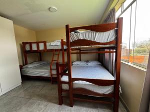 two bunk beds in a room with a window at Búnker de Coco in Pachacamac +73 photos