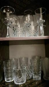 a bunch of glasses sitting on a shelf at Amber Home Kigali in Kigali