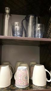 a shelf with jars and vases on it at Amber Home Kigali in Kigali +13 photos