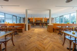 a restaurant with tables and chairs and windows at BABEL COMMUNITY Hôtel Bordeaux in Bordeaux
