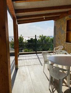 a patio with a table and chairs and a balcony at Casa palli in Camerota