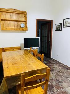 a dining room with a wooden table and a television at Casa palli in Camerota