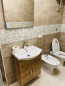 a bathroom with a sink and a toilet and a mirror at Casa palli in Camerota