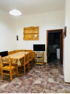 a dining room with a table and chairs and a television at Casa palli in Camerota +7 photos