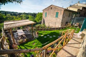 an old house with a garden in front of it at Il TramontO in Monticiano