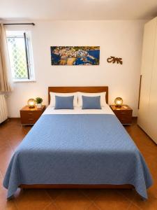a bedroom with a large bed with a blue blanket at Domus Pannella - Endless Summer in Lacco Ameno +31 photos