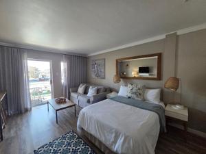 a bedroom with a bed and a living room at ShipsBell 5B in St Francis Bay