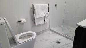 a white bathroom with a toilet and a shower at Lake Taupo Hotel in Taupo