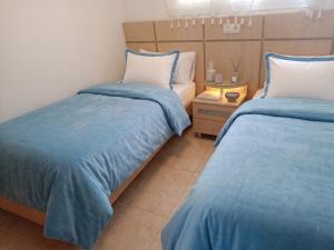 two beds in a room with blue and white at Jardines del mar III-2ª linea de playa Piscina y Parking Ideal familias Marina d'Or in El Borseral
