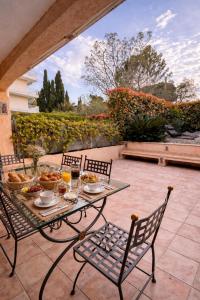 a table and chairs with food on a patio at Cap et Soleil Peaceful Private Garden, 2 Terraces, Pool, Garage, 5 Min Walk to Beach in Antibes