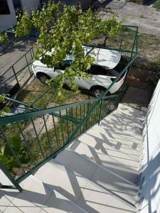 a white car parked next to a fence at Apartman LUCIJA, dostupan minimum 7 NOCENJA i VISE, AVAIBLE FOR RENT MINIM 7 NIGHTS AND MORE in Sutomore +3 photos