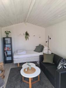 a living room with a couch and a bed at Gäststugan in Alingsås