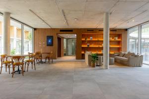 a living room with a table and chairs and a couch at BABEL COMMUNITY Hôtel Bordeaux in Bordeaux