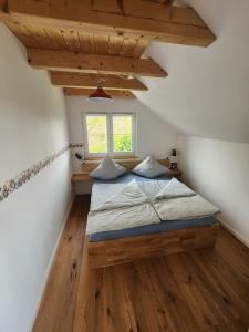 a bedroom with a bed in a room with wooden floors at Öko Wohnung Garten und Pool in Lindau-Bodolz +30 photos