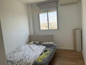 an unmade bed in a room with a window at דירת בוטיק מפנקת in Beer Sheva