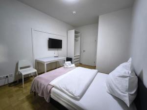 a bedroom with a bed and a desk and a television at FEWO Leonie 3 Schlafzimmer Apartment in Hückeswagen