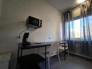 a room with a desk with a television on the wall at FEWO Leonie 3 Schlafzimmer Apartment in Hückeswagen +1 photo
