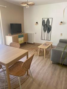 a living room with a table and a couch at logement avec accès piscine in Chaumont-sur-Tharonne