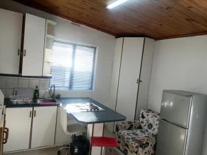 a small kitchen with a table and a refrigerator at 48 the trout lodge in Goodwood