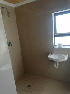 a bathroom with a sink and a window at 48 the trout lodge in Goodwood +8 photos