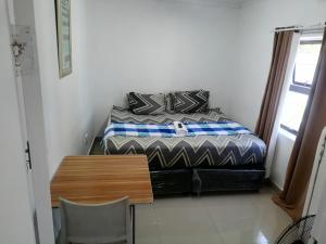 a small bedroom with a bed and a wooden table at 48 the trout lodge in Goodwood