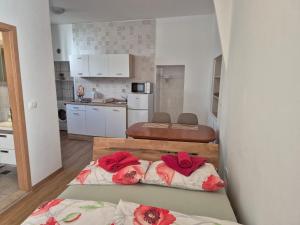 two beds in a kitchen with red pillows on them at ReginaMare Santa in Piran