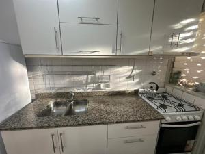 a kitchen with a sink and a stove at La Pausa Misiones in Posadas