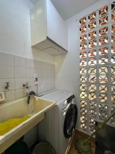 a kitchen with a sink and a washing machine at La Pausa Misiones in Posadas +11 photos