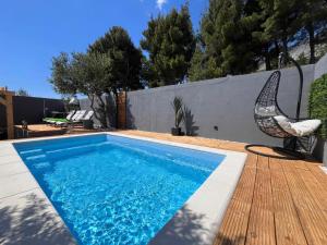 a swimming pool with a chair next to a fence at Luxury apartment Duće with private pool in Omiš