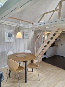 a dining room with a table and chairs and a staircase at Hyttan in Åkirkeby
