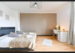 a bedroom with a large bed and a desk at Le sympathique in Ittenheim