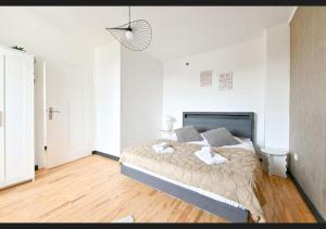 a bedroom with a large bed in a white room at Le sympathique in Ittenheim