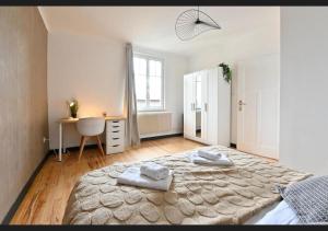 a bedroom with a large bed with two towels on it at Le sympathique in Ittenheim +21 photos