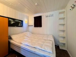 a bedroom with a large white bed in a room at Sandhåland Camping Hytte nr 7 in Sandhåland