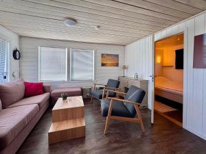 a living room with a couch and chairs and a bed at Sandhåland Camping Hytte nr 7 in Sandhåland