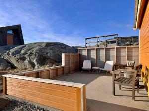 a patio with chairs and a table and a rock at Sandhåland Camping Hytte nr 7 in Sandhåland