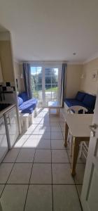 a living room with a couch and a table at Maisonnette duplex 4 pers proche mer et golf in Talmont
