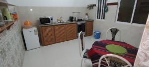 a small kitchen with a table and a refrigerator at Mycoffee Apartment in Mindelo