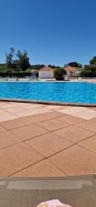 a swimming pool with blue water in the background at Maisonnette duplex 4 pers proche mer et golf in Talmont