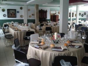 a room filled with tables and chairs with white table linen at Hostal San Francisco in Cuéllar
