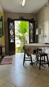 a kitchen with a table and chairs in a room at HOSTEL Divinópolis in Divinópolis