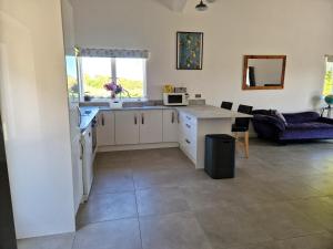 a kitchen with a sink and a table with a microwave at Mortimers Farm Barn in Saffron Walden +8 photos